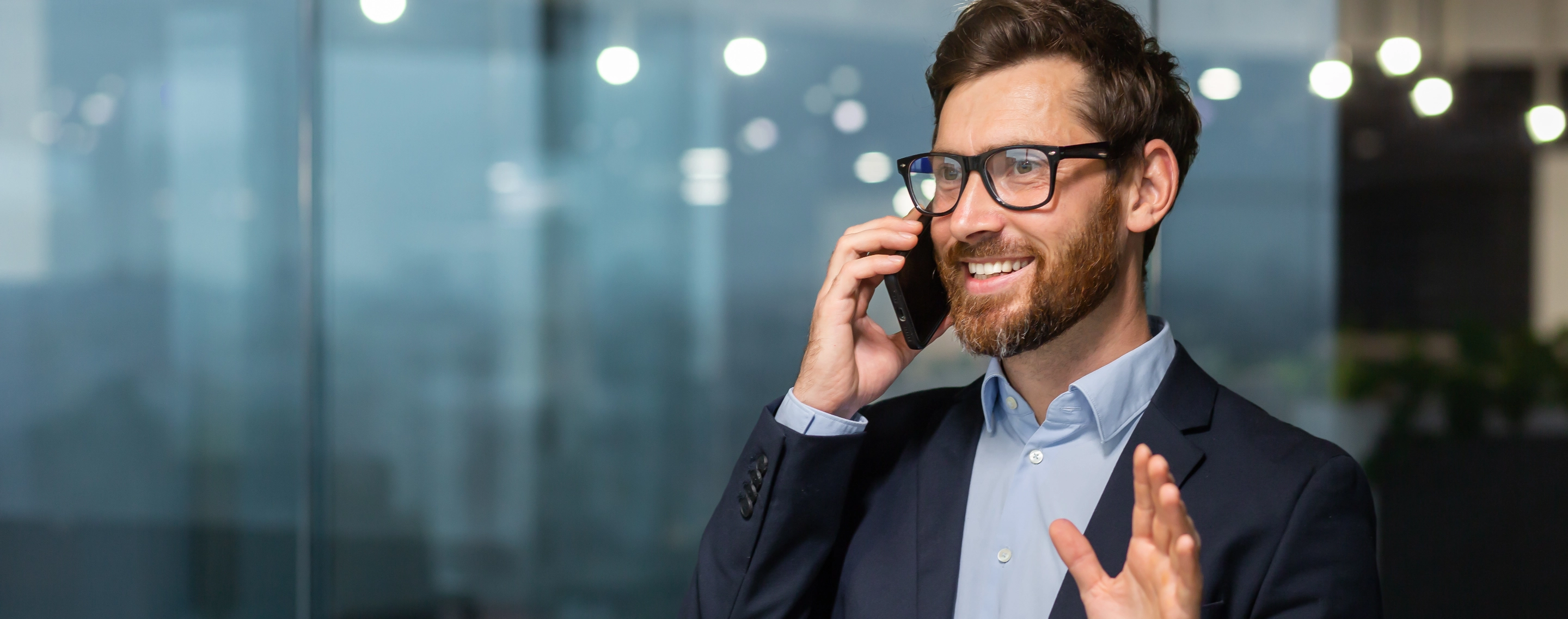 Ein Mann im Anzug telefoniert über ein Smartphone. 